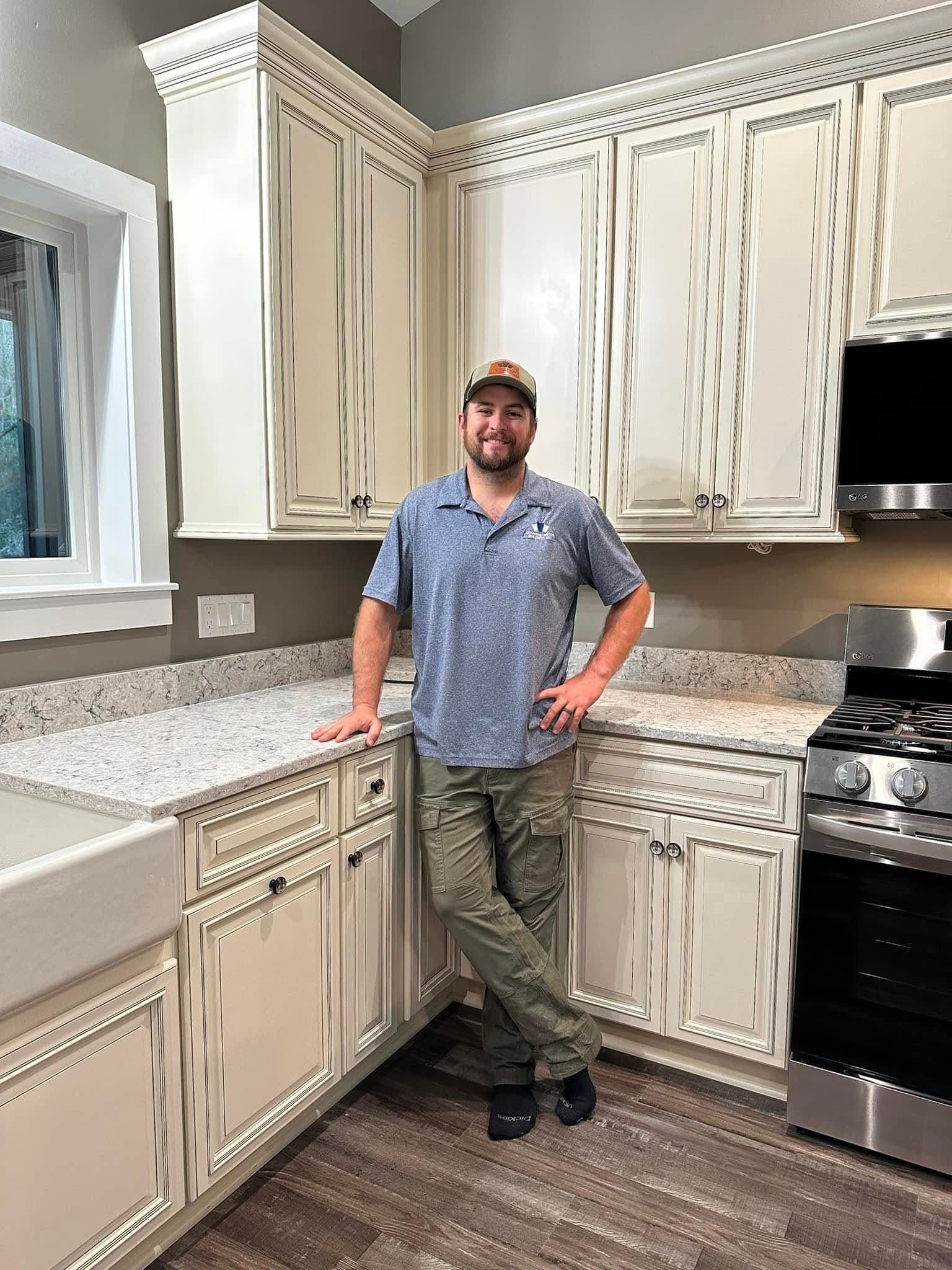 Robert Johnson in a newly finished custom kitchen with glazed cabinetry, granite countertops, and a farmhouse sink